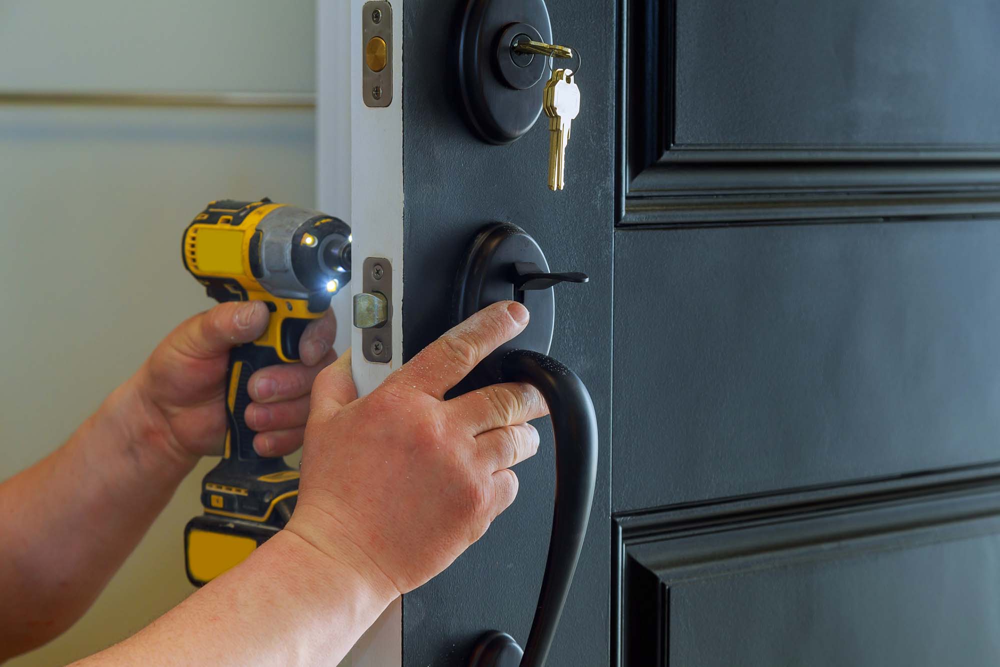 House exterior door with the inside internal parts of the lock visible of a professional locksmith installing or repairing a new d. Closeup of a professional locksmith installing a new lock on a house exterior door with the inside internal parts of the lock