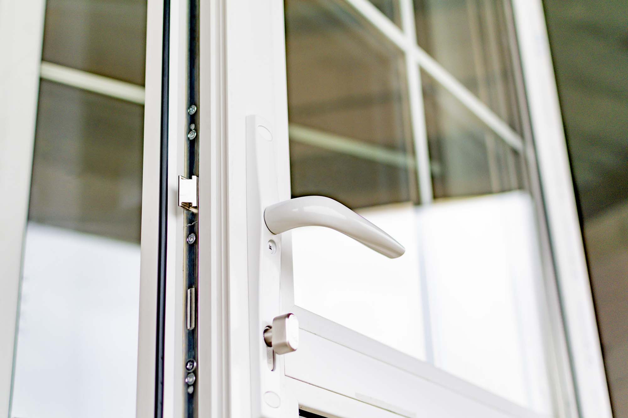 The pen is a new plastic door. The handle of the new plastic door. White front door in a house under construction